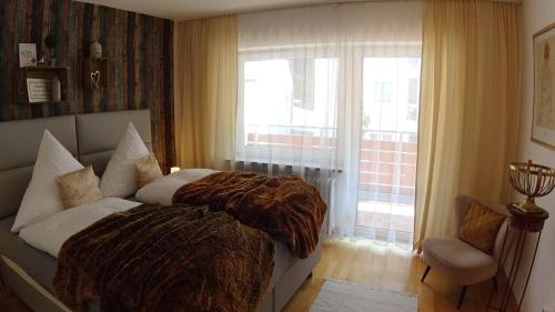 
a bedroom with two beds and a window at Parkresidenz Hotel Garni in Bad Abbach
