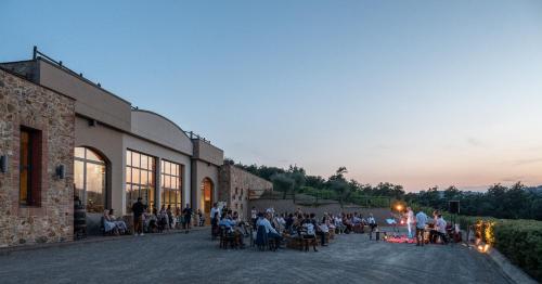a group of people sitting outside of a building at Fattoria Fibbiano in Terricciola