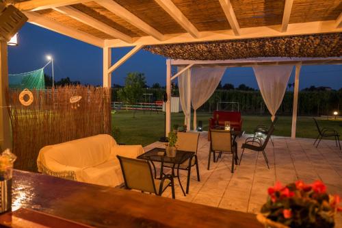 a patio with a couch and tables and chairs at Marion Apartments in Kourouta