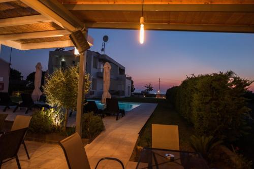a patio with chairs and a swimming pool at night at Marion Apartments in Kourouta