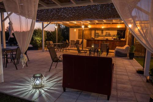 a patio with tables and chairs under a tent at Marion Apartments in Kourouta