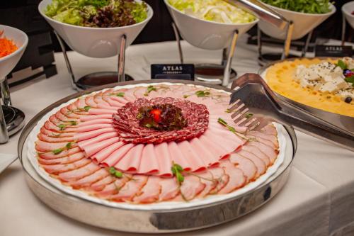 a table with a plate of food on a table at Hotel Atlas Deluxe in Lviv