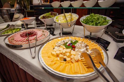 a buffet with cheese and other foods on a table at Hotel Atlas Deluxe in Lviv