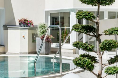 a swimming pool in a building with a tree at Hotel Andy 4 Sterne Superior in Jerzens
