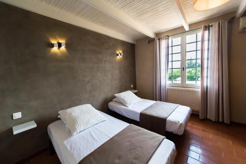 une chambre d'hôtel avec deux lits et une fenêtre dans l'établissement Camping Les Hautes Prairies, à Lourmarin