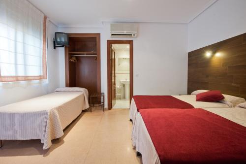 a hotel room with two beds and a bathroom at Hostal Sol in Toledo