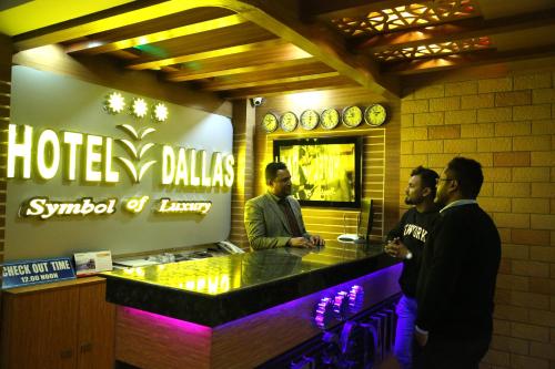 three men standing at a bar in a restaurant at Hotel Dallas Sylhet in Sylhet