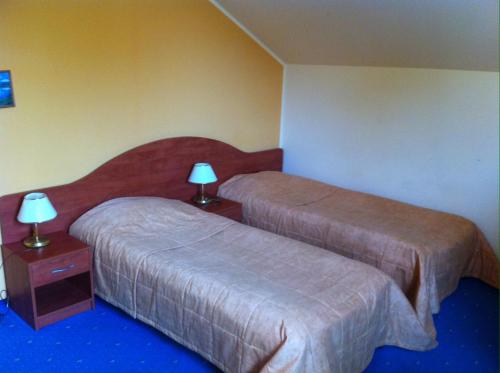 een hotelkamer met 2 bedden en 2 lampen bij Guest House Guba in Molėtai