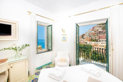 a bedroom with a balcony with a view of the city at Hotel Savoia in Positano