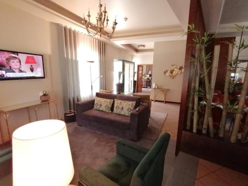 a living room with a couch and a chair at Residencial Imperial in Luso