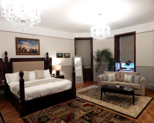 a bedroom with a bed and a couch at Tulloch Castle Hotel ‘A Bespoke Hotel’ in Dingwall