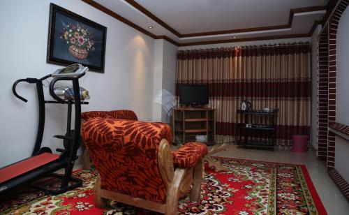 a living room with a chair and a television at Hotel Dallas Sylhet in Sylhet