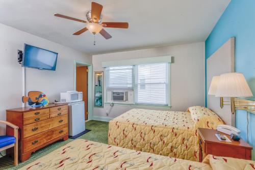 a bedroom with two beds and a ceiling fan at King Charles Hotel in Ocean City