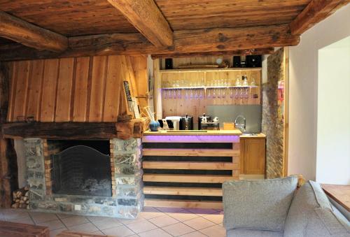 uma cozinha com uma lareira de pedra num quarto em LA JARBELLE - Gîte et Spa em Les Orres