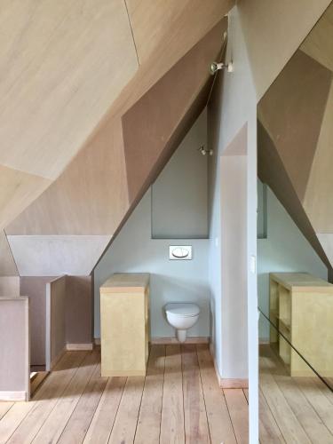 a bathroom with a toilet under the stairs at North Sea Cottage Middelkerke in Middelkerke