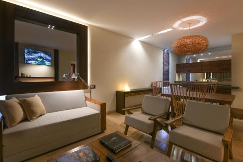 a living room with a couch and a dining room at Hotel Xcaret Mexico All Parks All Fun Inclusive in Playa del Carmen