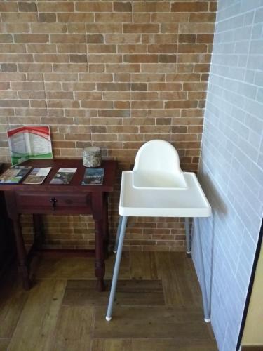 a white stool next to a desk with a brick wall at Casa rural meridiano in El Pinar del Hierro