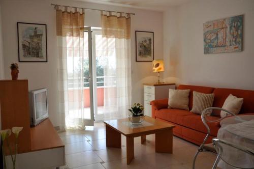 a living room with a red couch and a coffee table at Villa Matovica in Kampor