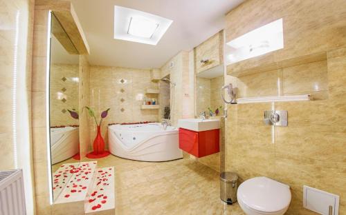a bathroom with a tub and a toilet and a sink at Hotel Imperium in Pionki