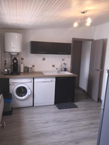 une cuisine avec un évier et une machine à laver dans l'établissement petite maison les sables d'olonne, à Les Sables-dʼOlonne