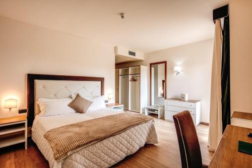 a bedroom with a bed and a dresser at Demidoff Country Resort in Pratolino