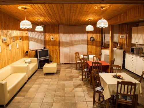 a living room with a couch and a table and a kitchen at Dunai Gyöngy Vendégház in Kisapostag