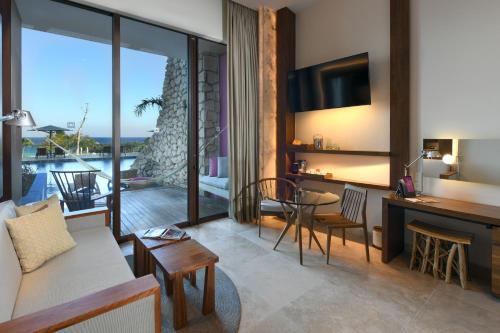 a living room with a couch and a table at Hotel Xcaret Mexico All Parks All Fun Inclusive in Playa del Carmen