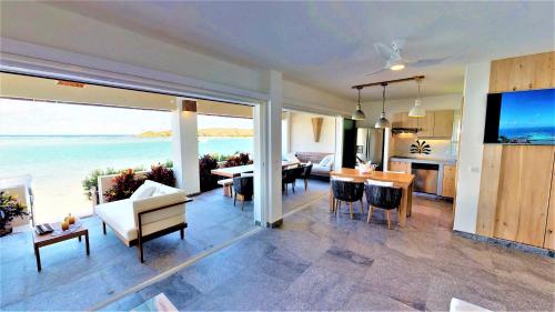 a kitchen and living room with a view of the ocean at Hotel Les Ondines Sur La Plage in Gustavia