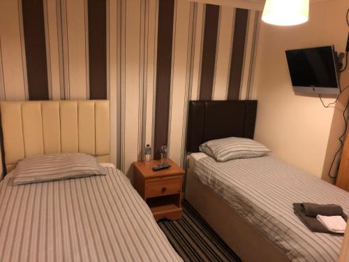 a hotel room with two beds and a tv at Saracen Head Hotel in Beith