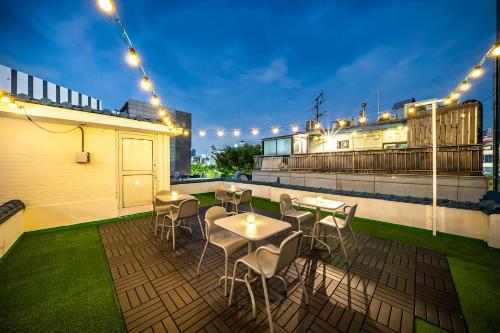 a patio with tables and chairs on a roof with lights at YAB-GuestHouse, FemaleOnly, ForeignOnly in Seoul