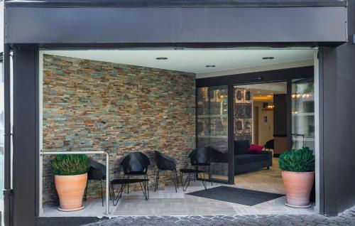 a lobby with chairs and a brick wall at Hôtel National in Lourdes