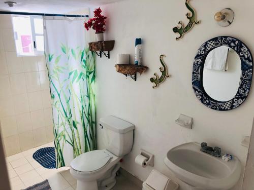 uma casa de banho com um WC, um lavatório e um espelho. em Casa Alberto Cozumel em Cozumel