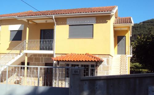 a yellow house with a fence in front of it at Alojamento Rodrigues in Arcos de Valdevez