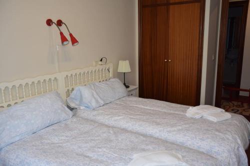 a bedroom with a large bed with two pillows at Precioso piso entre playa y monte in Górliz-Elexalde