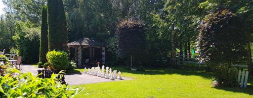 a garden with a gazebo in the grass at Landhaus Pfahlershof in Karolinenkoog