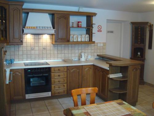 a kitchen with wooden cabinets and a table with a chair at W Starym Sadzie in Owińska