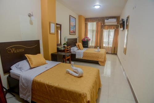 a hotel room with two beds in a room at Victoria Suites Hotel in Santo Domingo de los Colorados