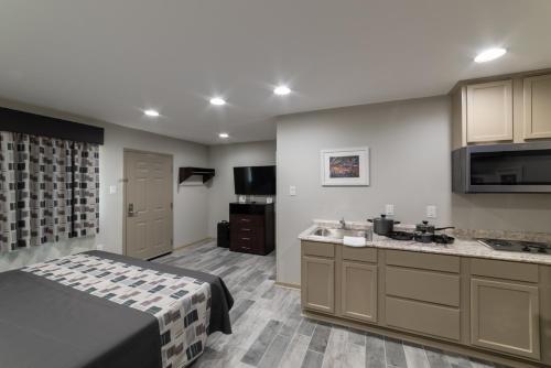 Budget Inn & Suites Baton Rouge في باتون روج: غرفة مع مطبخ مع سرير ومغسلة