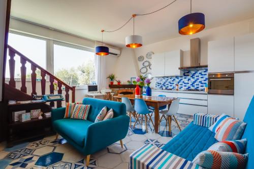 a living room with blue chairs and a table at Villa Sorrento Flats in Sorrento
