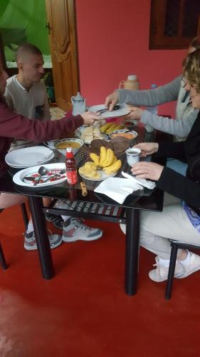 een groep mensen die rond een tafel zitten en eten bij Chanaka Holiday Inn in Sigiriya