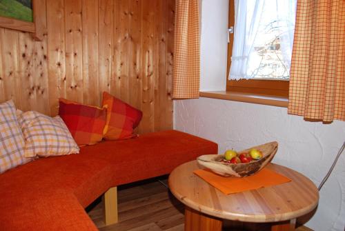a living room with a couch and a bowl of fruit on a table at Ferienhof Kleber Bauernhof - mit KönigsCard in Seeg