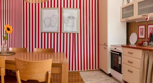 a kitchen with a table and a red and white striped wall at Apartment Štefánka in Púchov