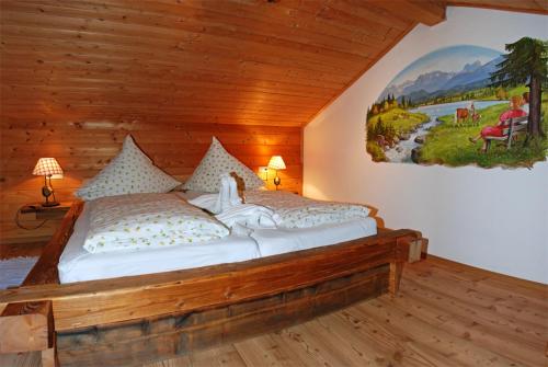 a bedroom with a bed with a painting on the wall at Ferienhof Kleber Bauernhof - mit KönigsCard in Seeg