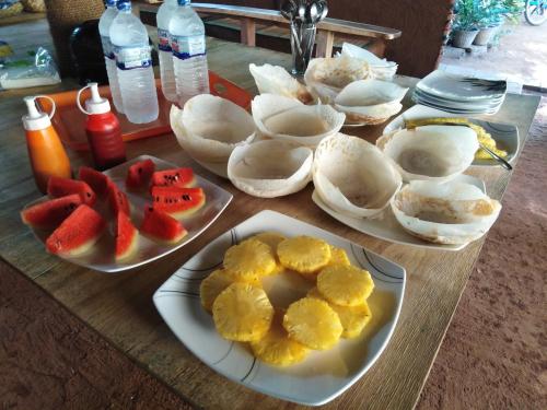 ein Tisch mit Tellern voller Speisen und Obst in der Unterkunft Udesh Guest in Polonnaruwa