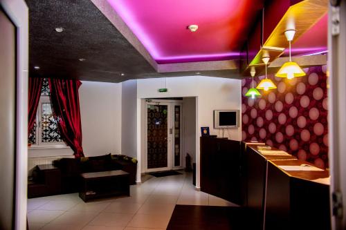 a restaurant with a bar with a purple ceiling at Pension Daciana in Bacău