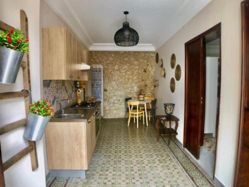 a kitchen with a sink and a table at “La Rampa” Affitti Brevi - Racalmuto (AG) Sicilia in Racalmuto