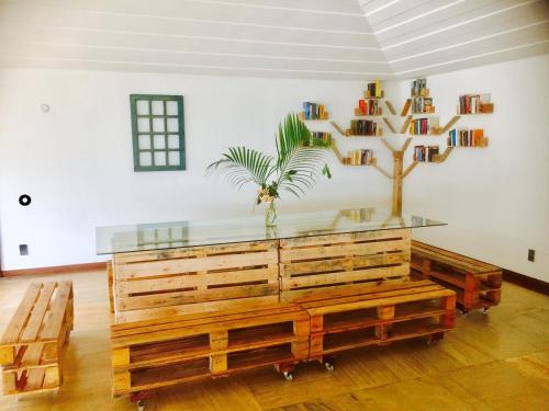 a room with a table and a palm tree in it at The Eco Palace Hostel in Búzios
