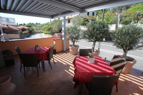 a patio with tables and chairs and potted trees at Pension Silvia in Portorož