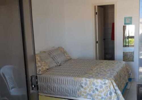 a bedroom with a bed and a door to a room at Apartamento em frente Mar in Salvador