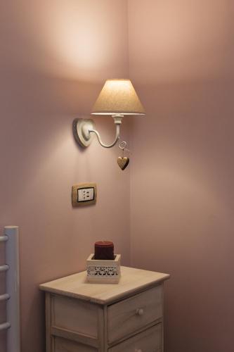 a table with a cake and a light on a wall at Alle Scalette B&B in Lauria